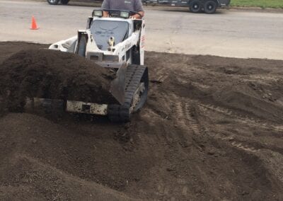 Worker with leveler to surface the land