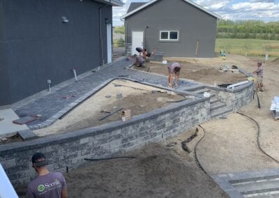 Workers setting the pavers for walkway